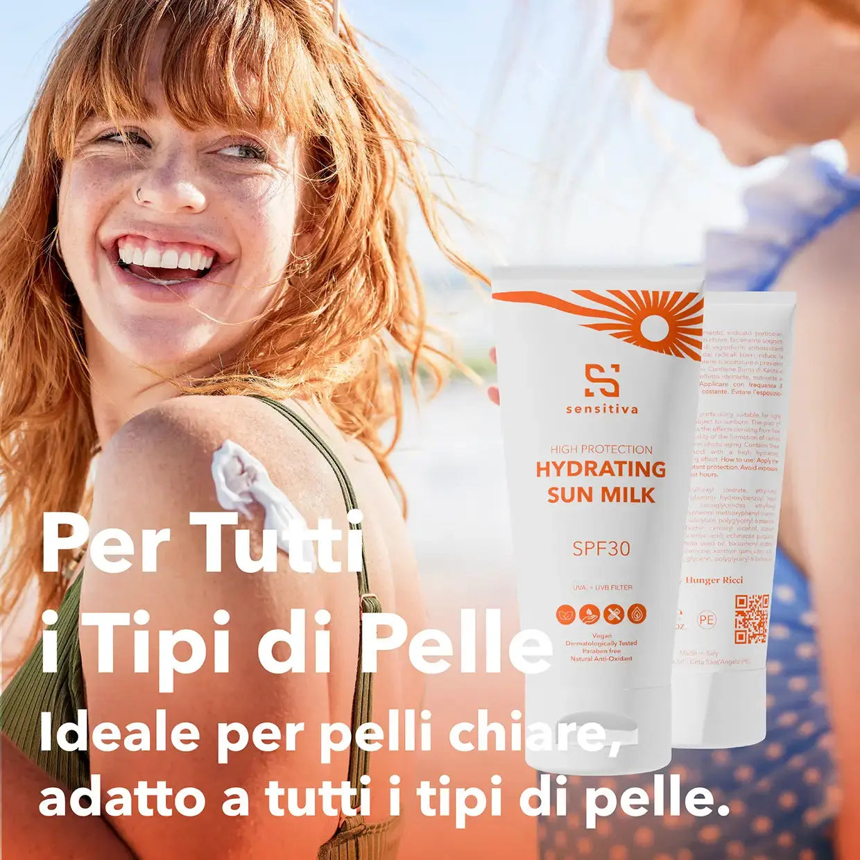 primo piano di una ragazza con i capelli rossi al mare che sorride ad un bambino